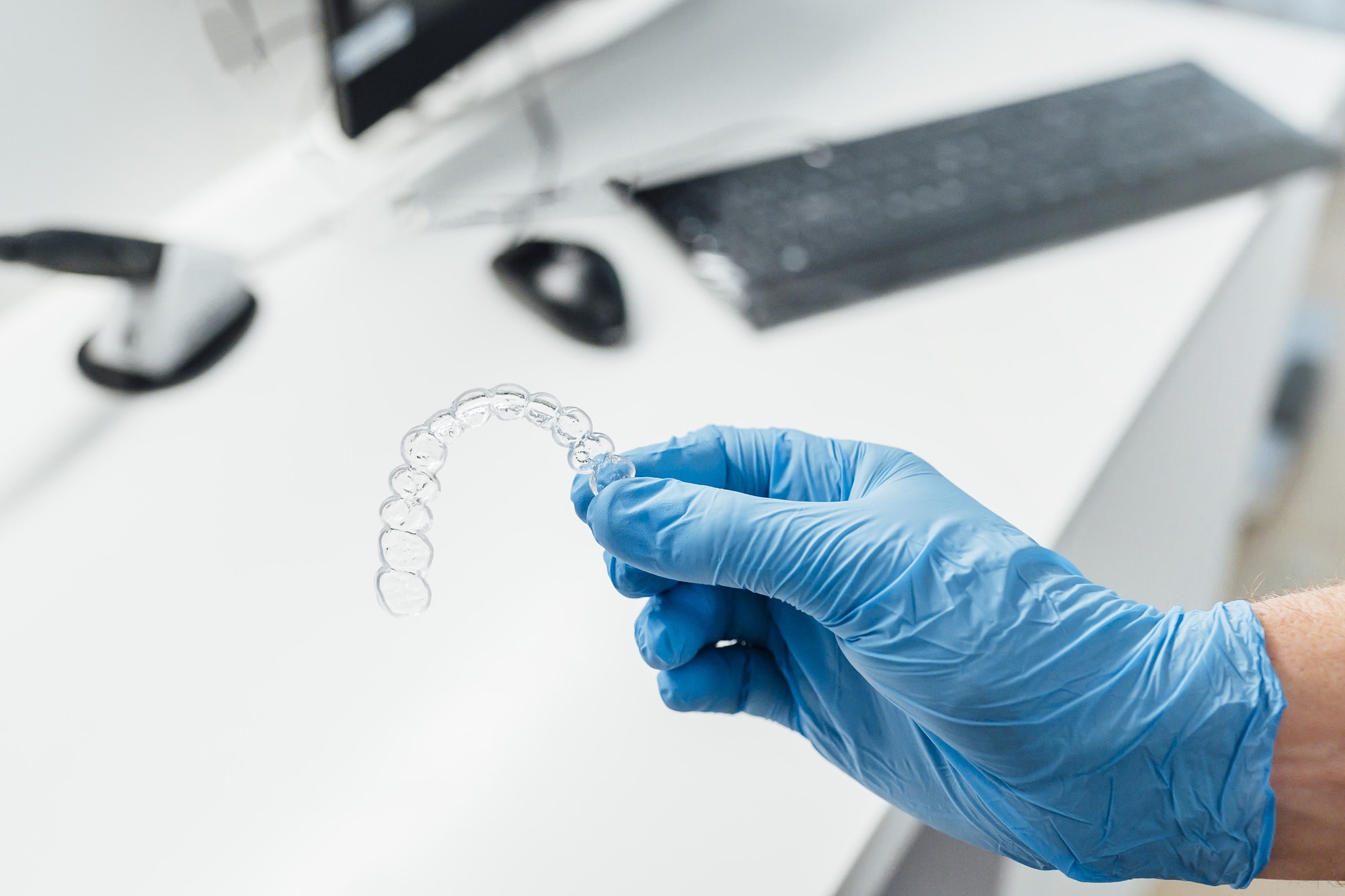 Doctor hand holding a clear dental aligner